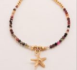 Bracelet en acierBracelet en pierres fines et breloque étoile de mer doré et perles multicolores avec charmes étoile de mer